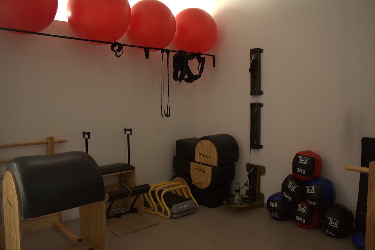Sala de Pilates Reformer con equipamiento de madera y luz natural